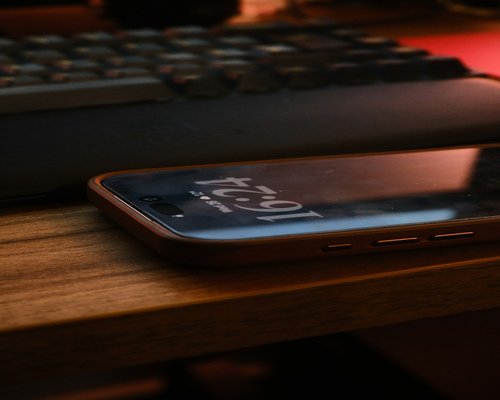 A clean workspace highlighting a smartphone with large accessible typography and soft screen glow