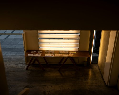 Soft incandescent light bulb casting warm ambient glow over a wooden reading table at night